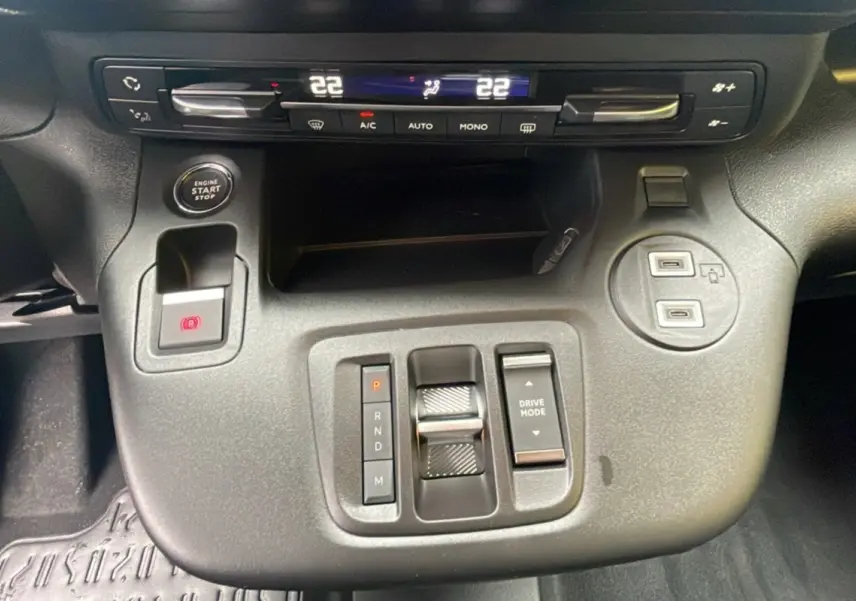 Vue rapprochée de la console centrale du Citroën Berlingo 2025, avec commandes de boîte auto et climatisation digitale.