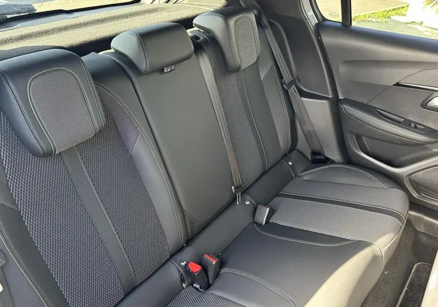 Vue intérieure côté droit des sièges arrière en tissu noir avec surpiqûres vertes de la Peugeot 208 Hybrid 145 e-DSC6 GT 2024