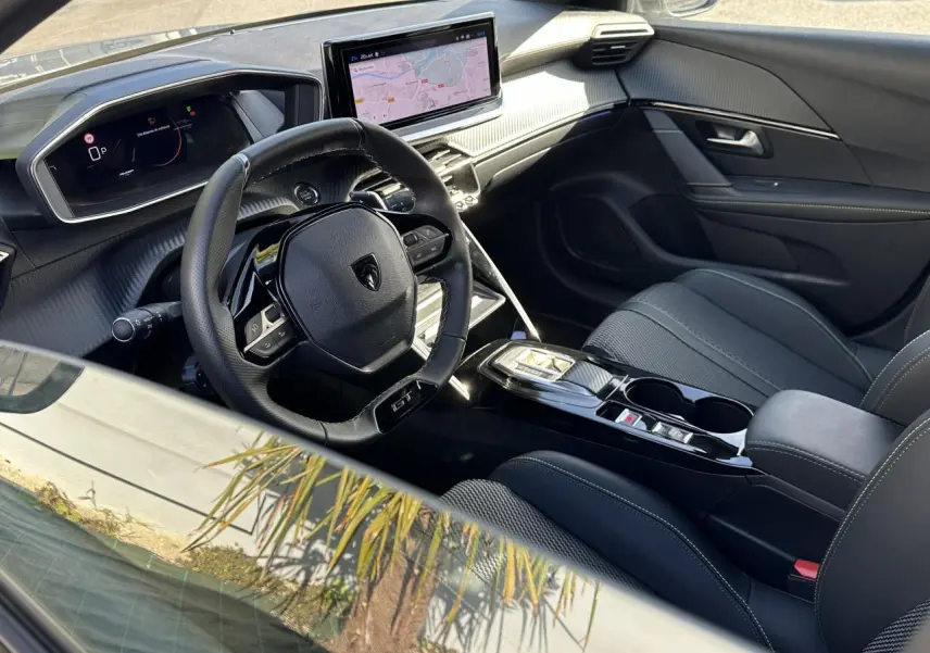 Intérieur avant droit de la Peugeot 208 Hybrid 145 GT 2024 avec tableau de bord numérique et écran tactile 10 pouces.