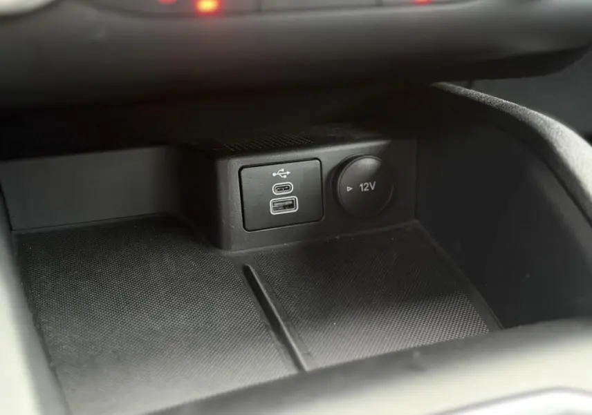 Détail de la console centrale du Ford Kuga 2024 noir Obsidien, avec ports USB et prise 12V visibles.