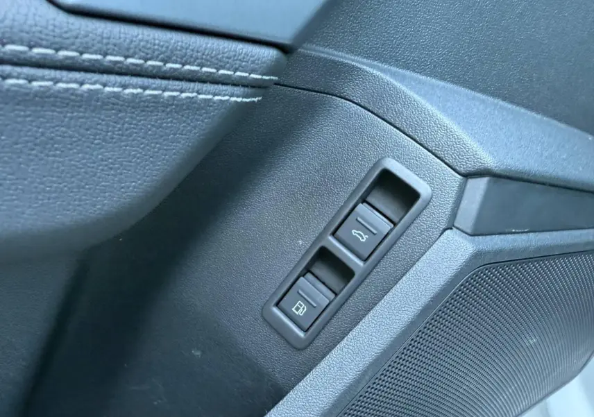 Détail intérieur côté conducteur de l'Audi A3 Sportback 2025 blanc Glacier, avec commandes ouverture coffre et trappe carburant.
