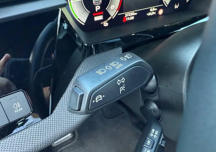 Gros plan sur la commande multifonction côté gauche du volant de l'Audi A3 Sportback blanc Glacier, avec tableau de bord numérique.