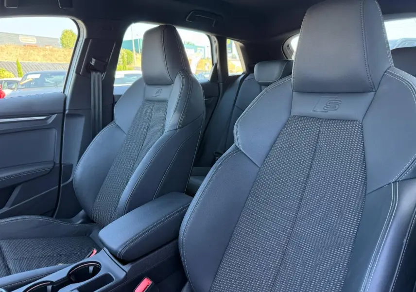Intérieur de l'Audi A3 Sportback 2025, vue rapprochée des sièges avant sport noirs avec logo S embossé.