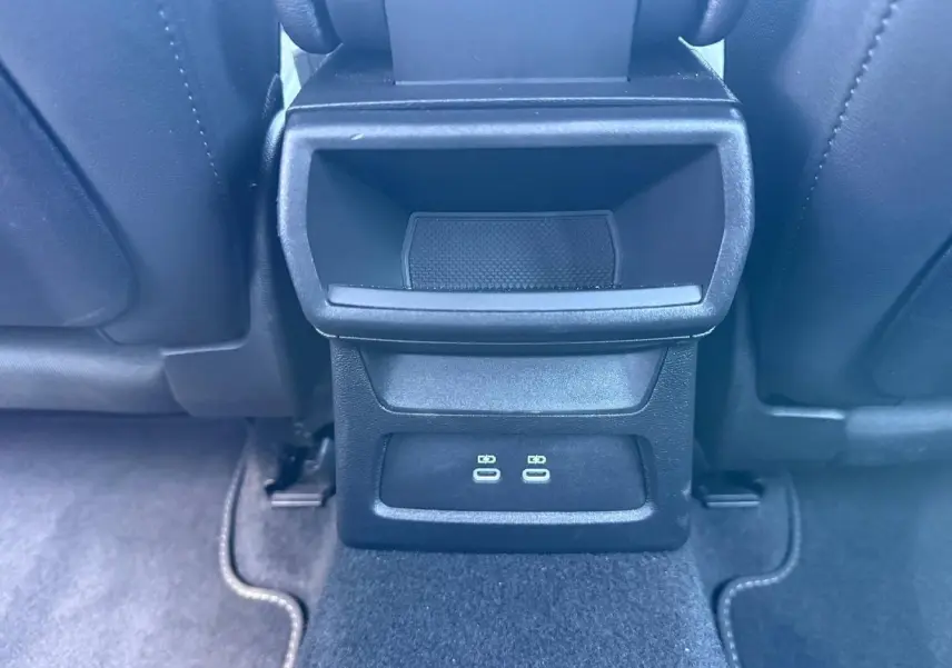 Détail de la console arrière noire avec deux ports USB-C, entre les sièges avant noirs de l'Audi A3 Sportback.