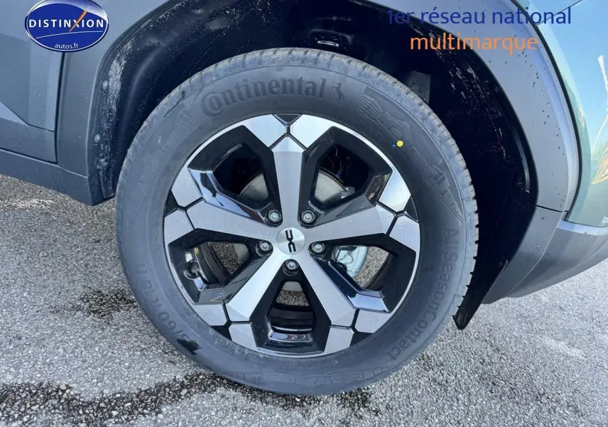 Gros plan sur la roue avant droite du Dacia Duster vert cèdre 2025 avec jante alu bicolore et pneu Continental.