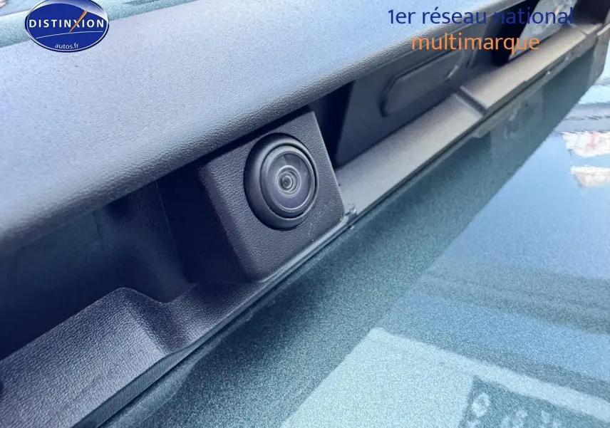 Gros plan sur la caméra de recul intégrée sur la porte arrière du Dacia Duster vert cèdre 2025.