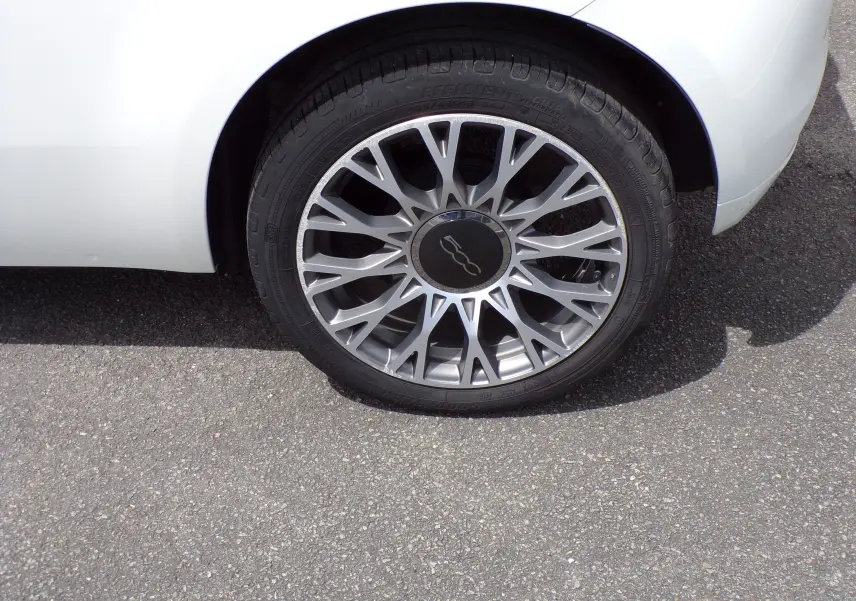 Gros plan sur la roue avant droite d'une Fiat 500 blanche de 2019 avec jante alliage 16 pouces bicolore.