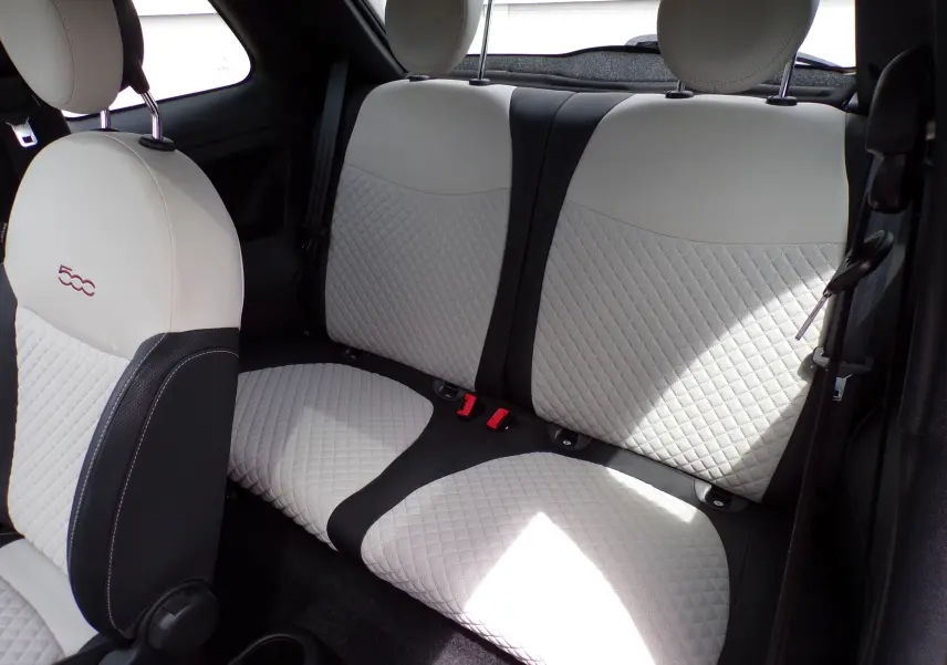 Vue intérieure arrière de la Fiat 500 2019 montrant les sièges arrière en cuir blanc et noir avec surpiqûres losanges.