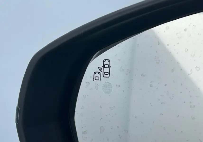 Gros plan sur le rétroviseur extérieur noir brillant du Citroën C5 Aircross bleu Eclipse Metal avec indicateur d'angle mort.