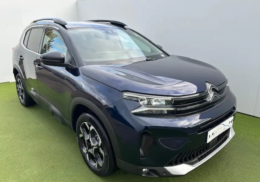 Vue 3/4 avant gauche d'un Citroën C5 Aircross bleu Eclipse métallisé avec calandre noir brillant et jantes diamantées.