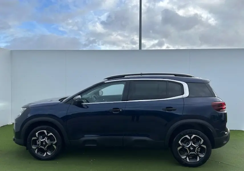 Profil côté gauche d'un Citroën C5 Aircross bleu Eclipse métallisé avec jantes alliage 18'' bi-ton et vitres surteintées.