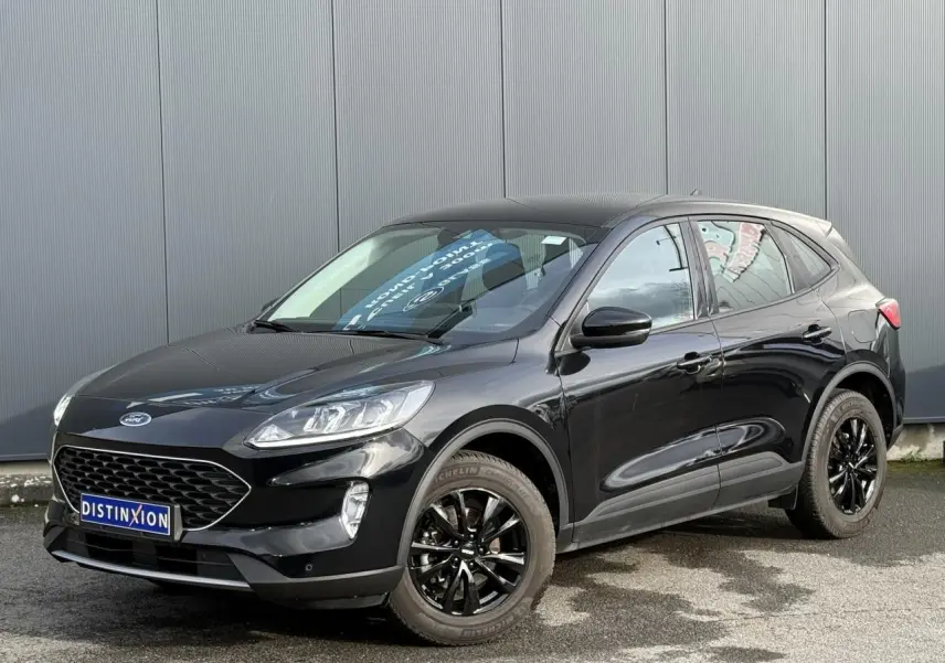 Vue 3/4 avant du Ford Kuga 2024 noir obsidien avec jantes alliage noires et attelage rétractable visible.