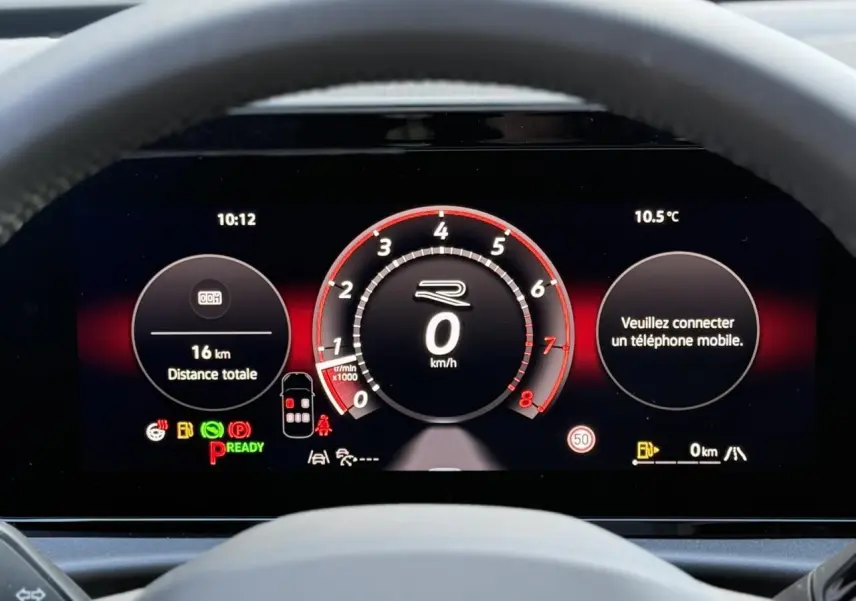 Vue rapprochée du tableau de bord numérique du Volkswagen T-Roc 2026, affichage noir avec compte-tours rouge et informations de conduite.