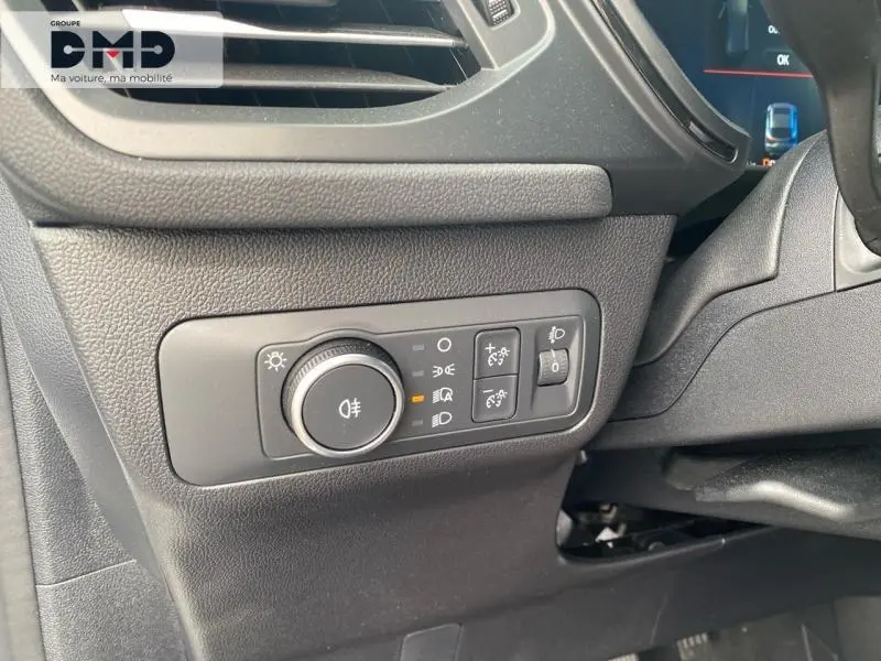 Détail du tableau de bord côté gauche du Ford Kuga blanc glacier 2026, avec commandes d'éclairage et réglages lumineux.