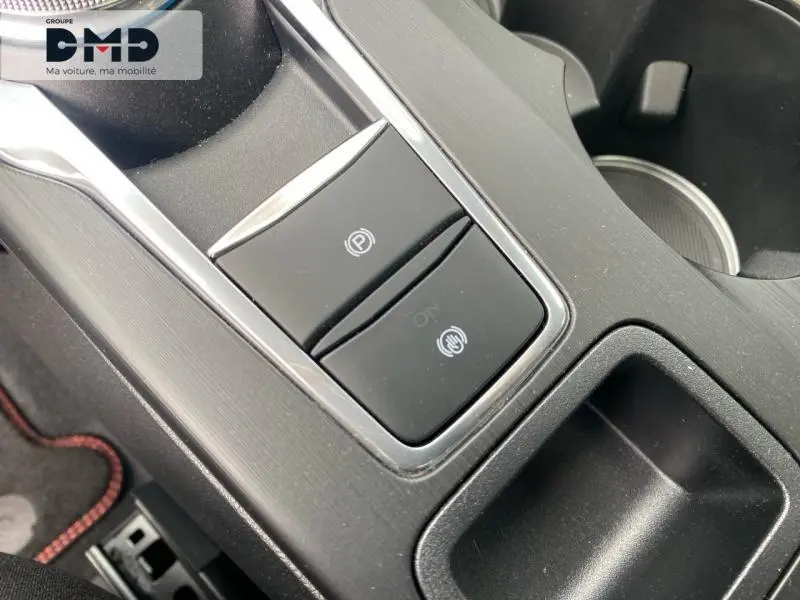 Gros plan sur la console centrale noire du Ford Kuga 2026 avec frein à main électronique et rangement adjacent.