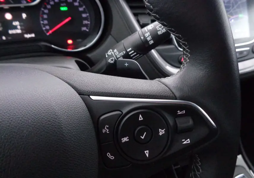 Gros plan sur le volant noir de l'Opel Grandland X 2021, montrant les commandes multimédia côté gauche.