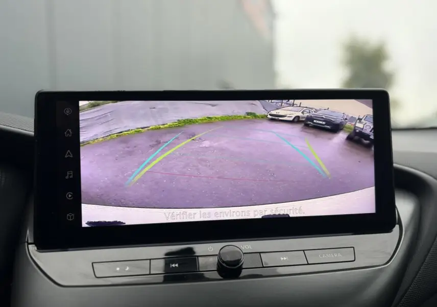 Écran tactile du Nissan Juke 2025 montrant la caméra de recul avec lignes de guidage colorées.