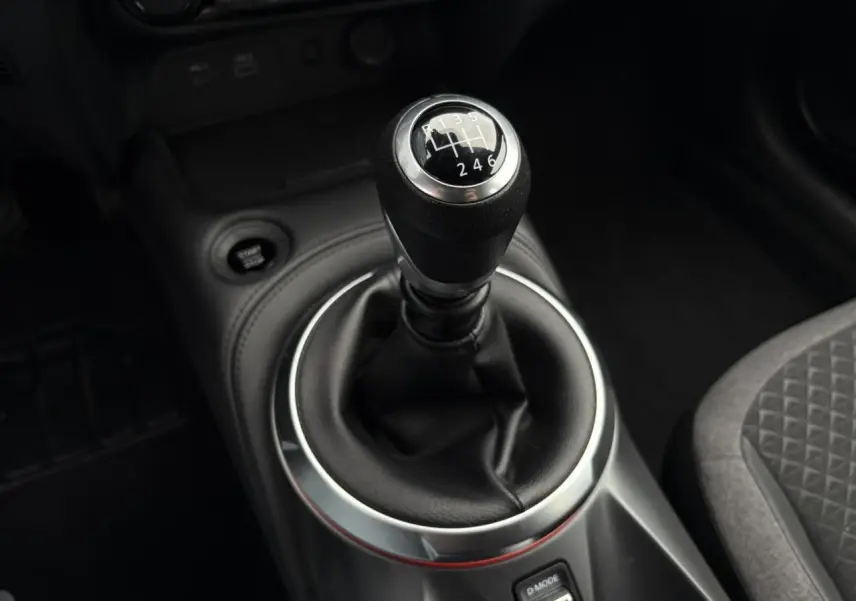 Gros plan sur le levier de vitesse manuel noir du Nissan Juke 2025, entouré d’un habillage argenté et cuir noir.