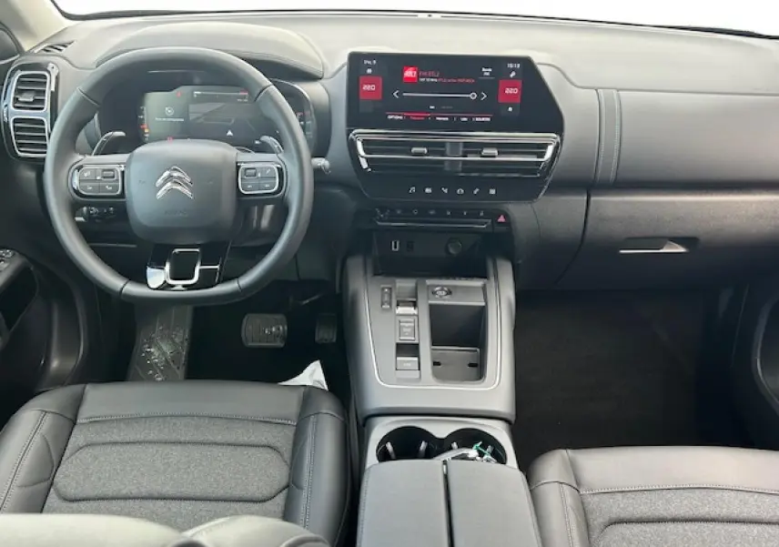 Intérieur avant du Citroën C5 Aircross 2025, tableau de bord moderne avec écran tactile et volant cuir gris.