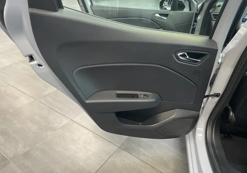 Vue intérieure de la porte arrière gauche gris Rafale de la Renault Clio 1.5 Blue dCi Evolution 2025 avec commande de vitre électrique.