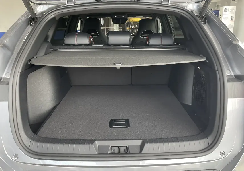 Coffre ouvert vu de l'arrière d'un BYD SEAL U Time Grey avec cache-bagages et sièges arrière noirs.