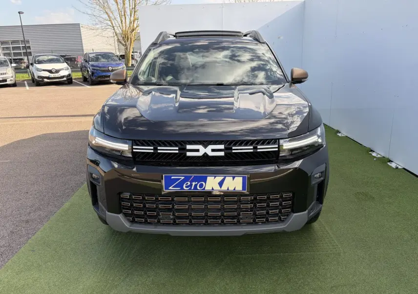 Vue avant d'un Dacia Bigster noir nacré avec calandre brun cuivré et toit panoramique ouvrant.