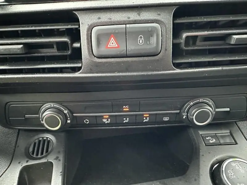 Détail du tableau de bord du Citroën Berlingo van gris métal 2020, montrant les commandes de climatisation et les boutons d'alerte et verrouillage.