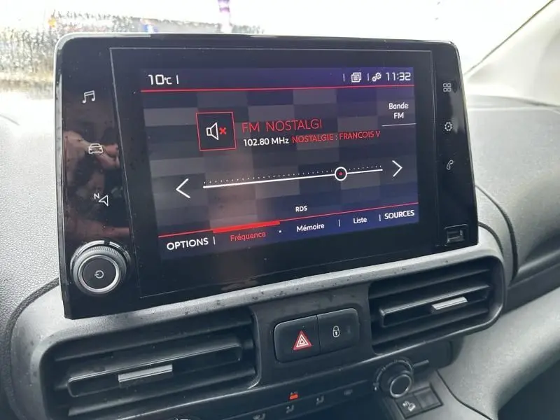 Écran tactile central du tableau de bord du Citroën Berlingo van gris métal, affichant la radio FM Nostalgie à 102,80 MHz.
