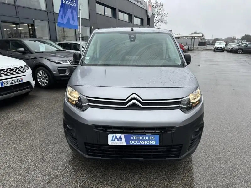 Vue frontale d'un Citroën Berlingo van gris métal 2020 avec phares allumés et plaque "Véhicules Occasions".
