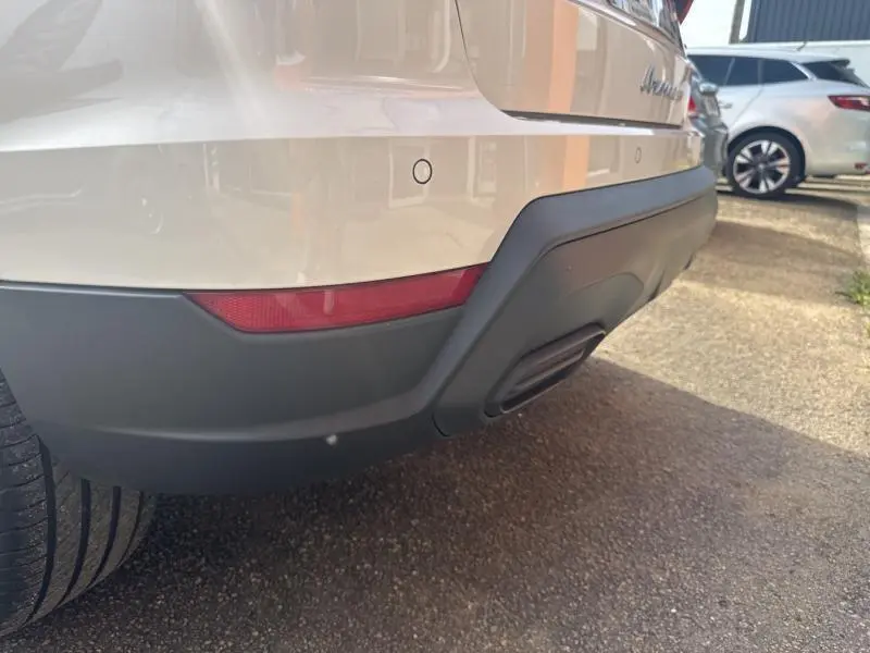 Gros plan sur le pare-chocs arrière blanc Nevada Métal du SEAT Arona 2022 avec diffuseur noir et feu rouge latéral.