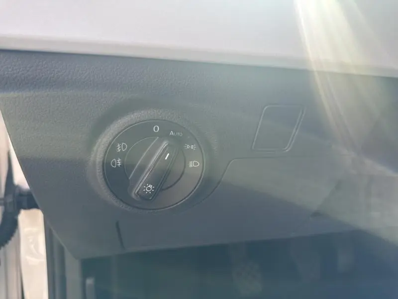 Gros plan sur la commande des phares du tableau de bord du SEAT Arona blanc Nevada Métal avec toit gris magnétique.