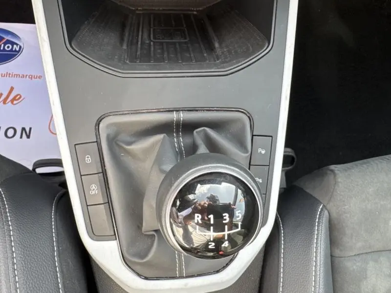 Levier de vitesse manuel noir avec coutures blanches dans l'habitacle du SEAT Arona blanc Nevada 2022.