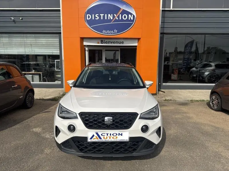 SEAT Arona blanc Nevada avec toit gris Magnétique, vue frontale, calandre noire et phares LED triangulaires.