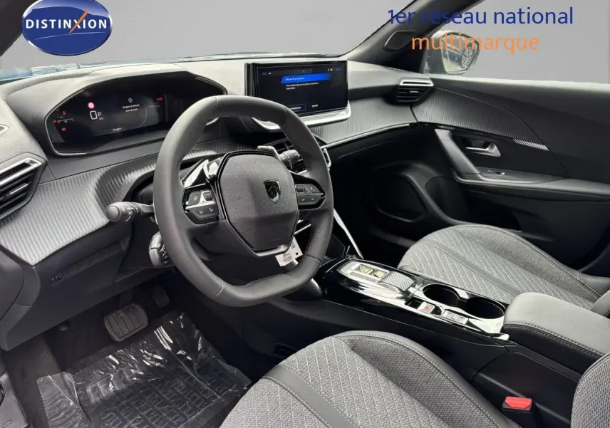 Vue intérieure côté conducteur du Peugeot 2008 Hybrid 136ch Allure 2025, avec tableau de bord numérique et sièges gris.