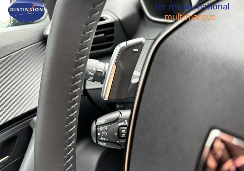 Gros plan sur le volant et les commandes de régulateur de vitesse du Peugeot 2008 Hybrid 136ch finition Allure.