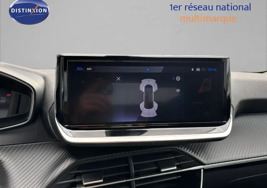 Écran tactile central du tableau de bord du Peugeot 2008 Hybrid 136ch Allure avec finition carbone et affichage de capteurs de proximité.
