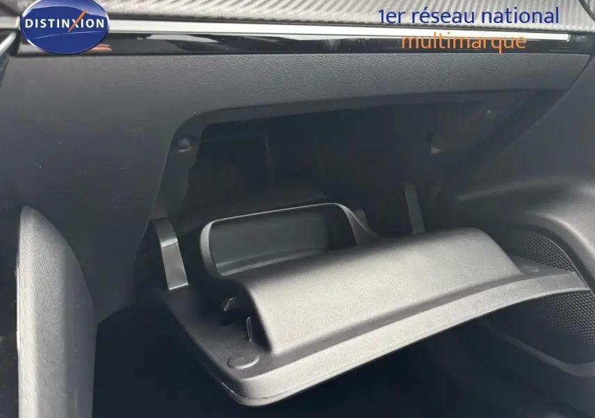 Gros plan sur la boîte à gants ouverte de la Peugeot 2008 Hybrid 136ch Allure, intérieur noir moderne.