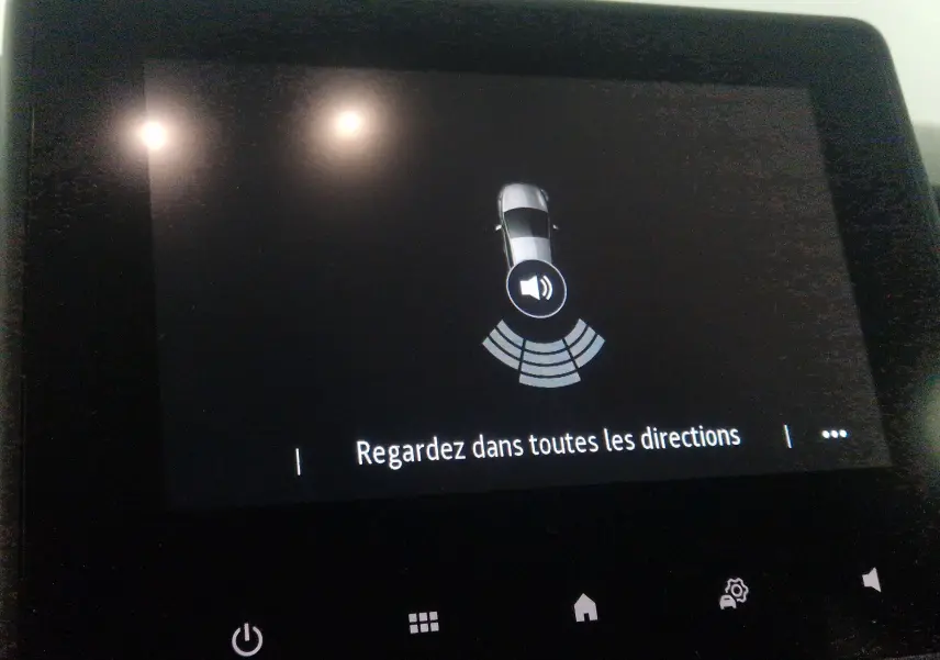 Écran tactile intérieur montrant l'alerte de proximité avec vue schématique d'une Renault Clio V gris platine.