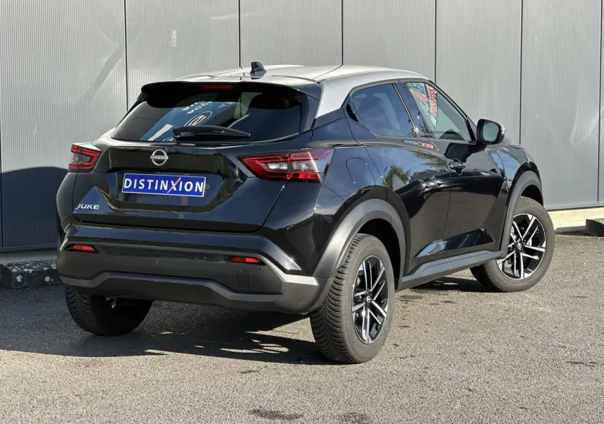 Nissan Juke noir vue 3/4 arrière droit, avec toit contrasté gris et jantes alliage 17 pouces.