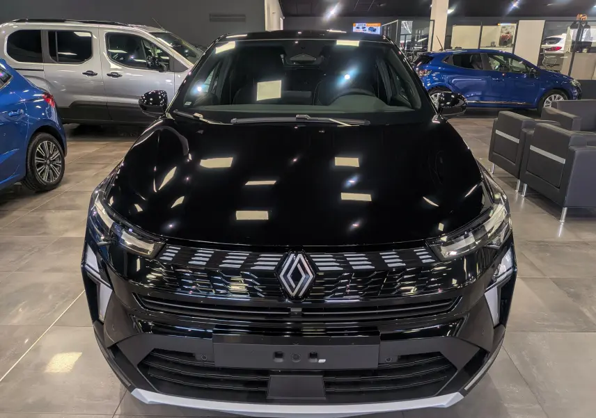 Vue avant d’un Renault SYMBIOZ E-Tech full hybrid noir étoilé, avec calandre moderne et éclairage LED en showroom.
