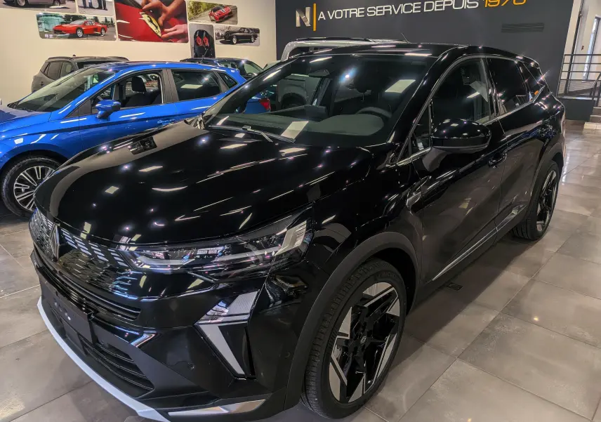 Renault Symbioz E-Tech noir étoilé en 3/4 avant droit, SUV hybride avec jantes noires et détails chromés visibles.