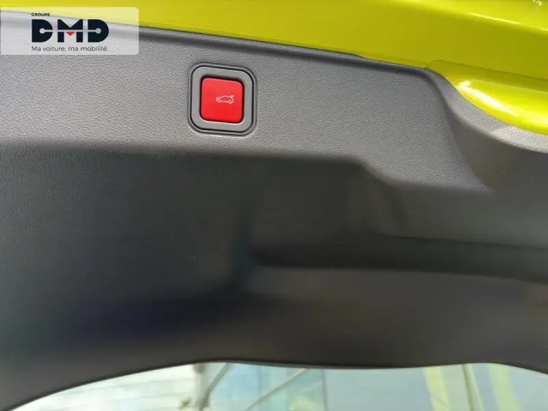Détail du bouton d'ouverture électrique du coffre sur le hayon vert Méditerranéen métallisé d'une FIAT 600 hybride.