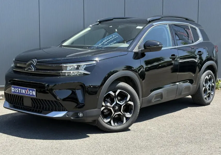 Vue 3/4 avant droite du Citroën C5 Aircross Hybrid 145 noir Perla avec jantes alliage et barres de toit noires.