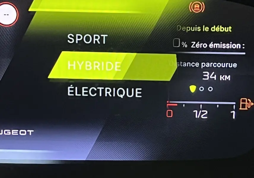 Affichage numérique intérieur de la Peugeot 308 GT PHEV 180 blanc nacré montrant le mode hybride en surbrillance.