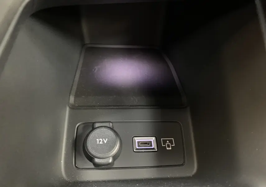 Prise 12V et port USB-C dans le compartiment central de la Peugeot 308 GT PHEV blanc nacré, vue rapprochée intérieure.