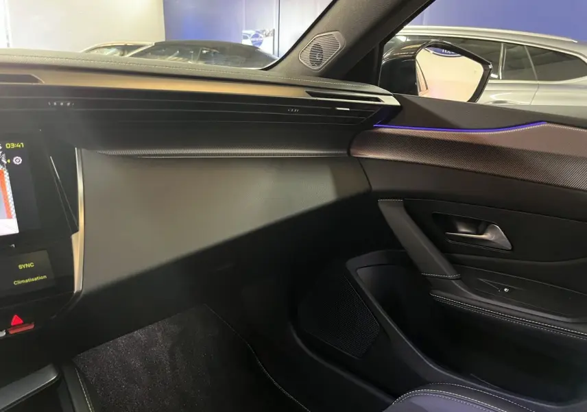 Intérieur de la Peugeot 308 GT PHEV 2022 vu côté passager, avec tableau de bord noir et éclairage d'ambiance violet.