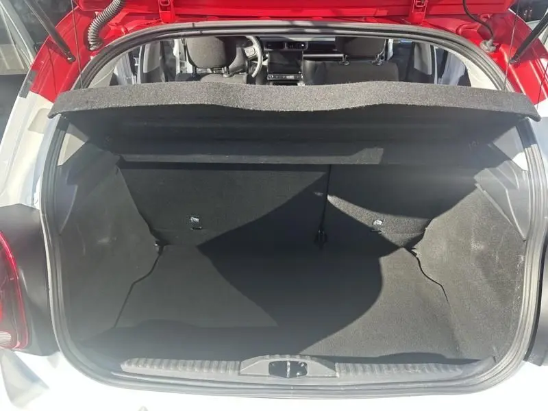 Coffre ouvert d'une Citroën C3 blanc avec toit rouge, vue arrière montrant l'espace de chargement vide et intérieur sombre.