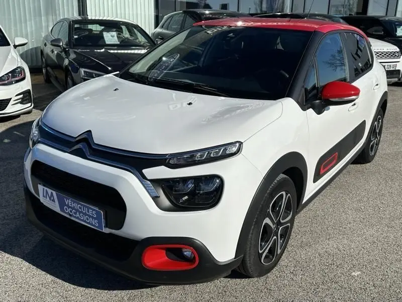 Citroën C3 1.2 PureTech 110 Feel Pack blanc avec toit et rétroviseurs rouges, vue 3/4 avant droit.