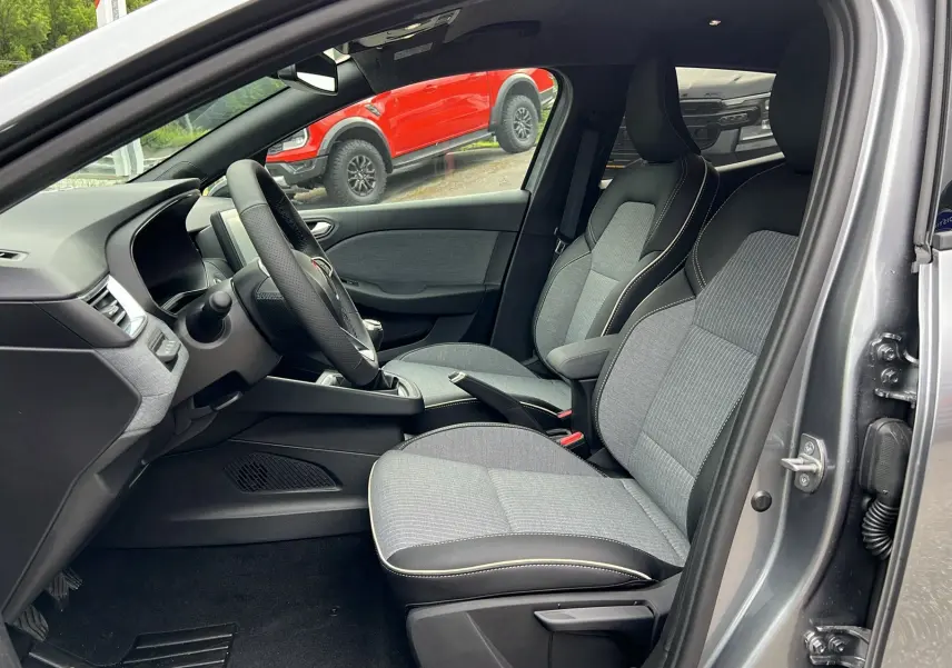 Intérieur de la Renault Clio V TCE 90 TECHNO 2025 gris schiste, vue côté gauche sur les sièges avant et tableau de bord.