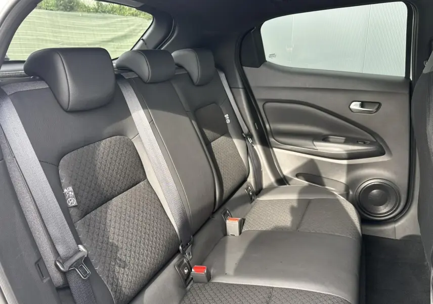 Vue intérieure côté droit des sièges arrière noirs du Nissan Juke 2025 avec garnitures en tissu et cuir.